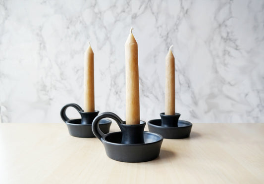 https://stuckinthemudpottery.com/cdn/shop/products/black-ceramic-candlestick-holder-with-handle-taper-holder-5c68b0f3.jpg?v=1569232795&width=533